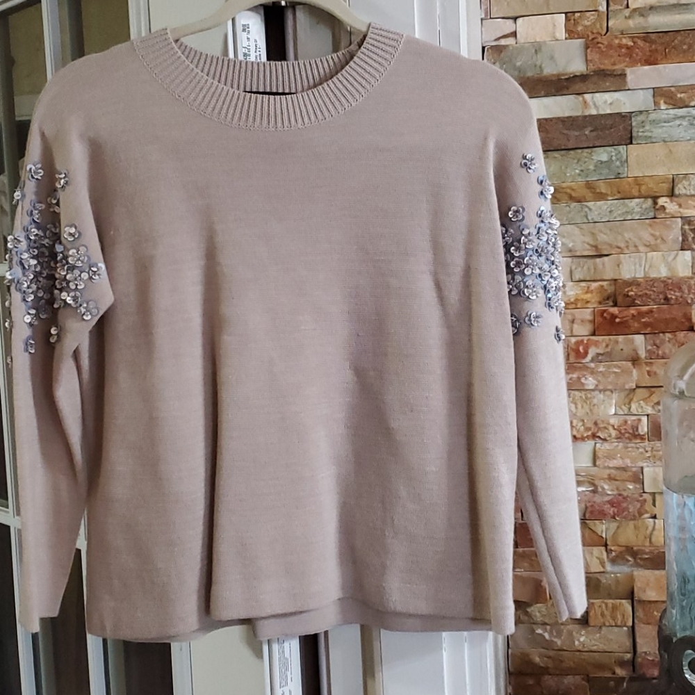 Light sweater with sequences on sleeves
